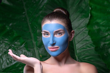 Beauty Spa Woman with perfect skin Portrait. Beautiful Brunette Spa Girl showing empty copy space on the open hand palm for text. Proposing a product. Gestures for advertisement.