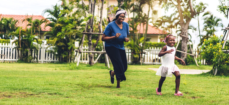 Portrait of enjoy happy love black family african american mother and little african girl child smiling running and having fun moments good time in summer park at home