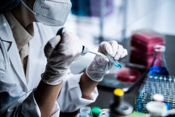 新型コロナウイルスを分析する研究室で実験を行う科学者