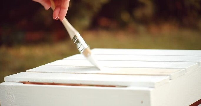 Painting the wooden box with brush and white paint