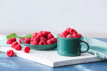 Plate with tasty ripe raspberries on table