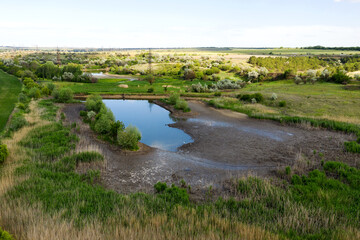 Fototapeta na wymiar Grass and dry alkali lake bottom at Summer. Abnormal drought, ecological disaster