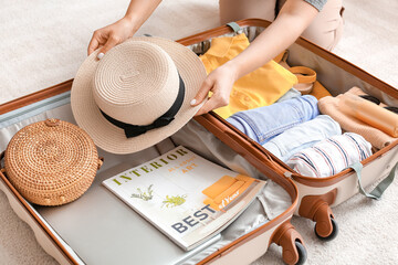 Woman packing suitcase at home. Travel concept