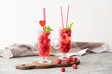 Cups of cold raspberry tea on table