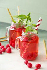 Mason jars of cold raspberry tea on table