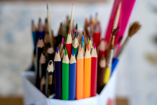 colorful pencils and school supplies in a jar on the windowsill on a Sunny day, the concept of starting school after the holidays, selective focus, tinted image