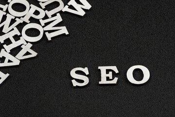 Word SEO is composed of white letters on black background. Website optimization concept