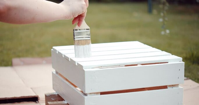 Painting the wooden box with brush and white paint