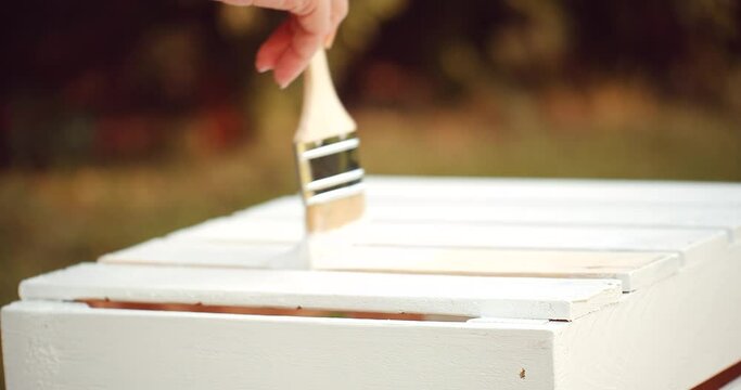Painting the wooden box with brush and white paint