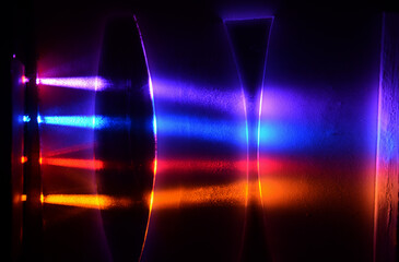 Light beams in colorblind-friendly colors pass trough a concave and a convex demonstration lens, the influence on the beams can be seen on the screen