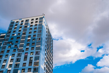 Fototapeta premium A fragment of a modern residential apartment with a flat building facade. Detail of a new luxury home and residential complex. Part of urban real estate and condominium architecture., copy space