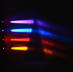 Four different light beams are refracted in a triangular 30 degrees prism on a dark background.