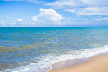 The beach and sea surface with Deep Blue sea clear sky clouds. Landscape with Ocean small waves water reflection copy space for text. Illustration for tourism, website or ad. Andaman sea, Thailand.