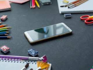 School supplies are on the black background of the Board. In the center