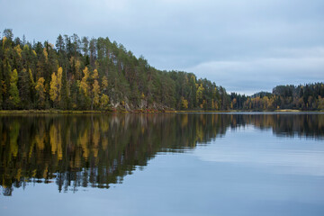 Fototapeta na wymiar Reflection of colorful trees on a lake surface during autumn foliage near Kuusamo, Finland, northern Europe