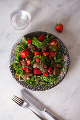 Chicken liver salad with strawberries and arugula. Liver and berries salad. overhead vertical photo