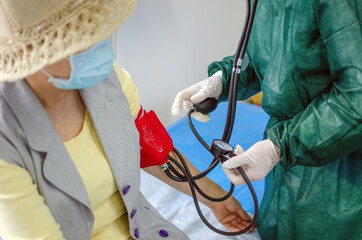 Nurse Taking the Blood Pressure of an Old Woman