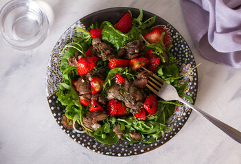 Chicken liver salad with strawberries and arugula. Liver and berries salad. overhead horizontal photo