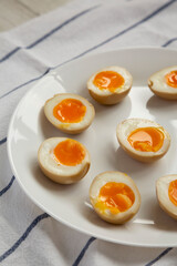 Homemade Unami Soy Sauce Eggs on a white plate, low angle view.