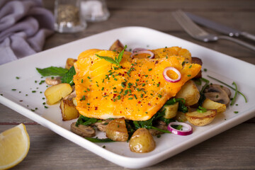 Cod fish fillets with potatoes, mushrooms and spinach on white plate. horizontal photo