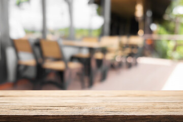 Empty wooden desk space and blurry background of coffee shop or Restaurant for product display montage.