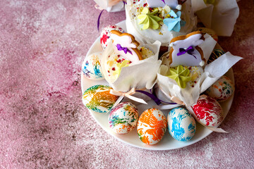 Easter bright multicolored eggs with Easter pies on a white ceramic plate