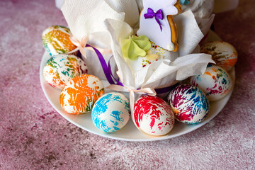 Easter bright multicolored eggs with Easter pies on a white ceramic plate