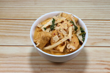 Traditional spicy red curry of sliced pickled bamboo shoot, chilly, fried tofu, fresh basil and coconut milk in the bowl. Famous hot and spicy vegetarian soup menu in Asia restaurant. 