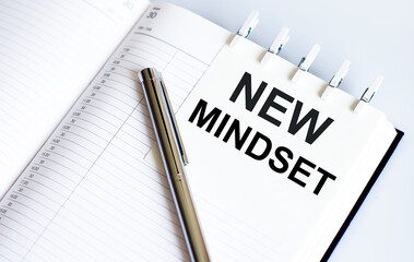 text NEW MINDSET on the short note texture background with pen
