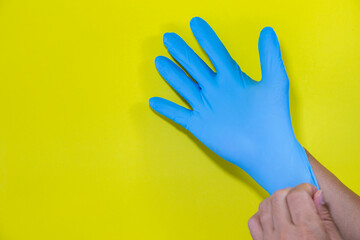 Photos of medical gloves To prevent germs Blue on yellow background