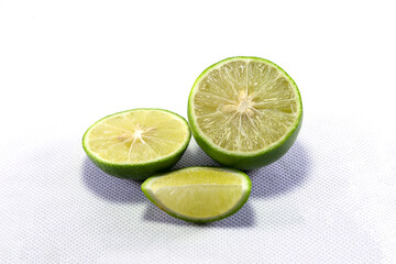 Green Thai Lime Cut in half and cut into pieces Close-up shot on a separate white background