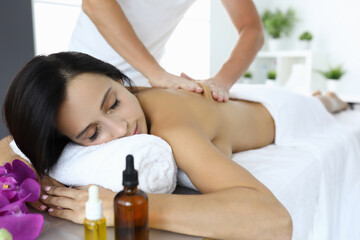 Obraz na płótnie Canvas Woman is given massage to relieve tension and stress. Services of beauty salons and spa concept