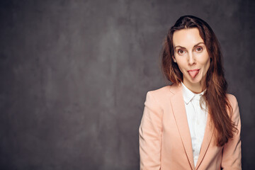 Adult woman sticking out tongue on dark background