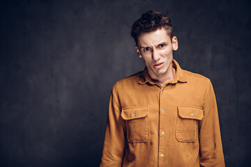Dissatisfied young caucasian man on dark background