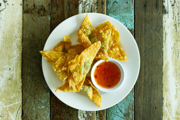 Fried dumpling and spicy sauce on wood table