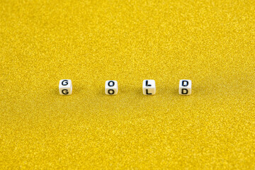 gold word formed by white dices with black letters  laying on golden background.