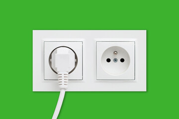 Brand new electrical socket isolated on green wall. White wire plug plugged in. Renovated studio apartment power supply background. Empty copy space double white plastic power outlet. 