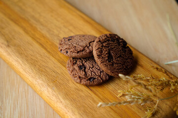 chocolate cookies and dark chocolate grain on wooden board background. for text concept advertising