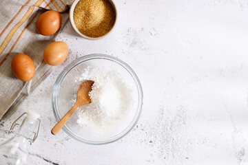Baking and cooking ingredients on white marble background.