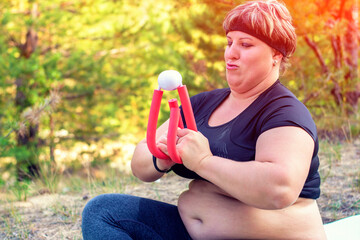 Plus size female model in sports uniform is engaged in sports. Positive oversized young caucasian woman in nature.