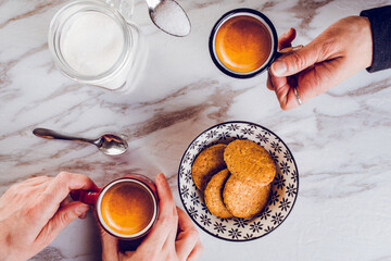 Foto di due mani che sorreggono due tazzine da caffè a colazione 