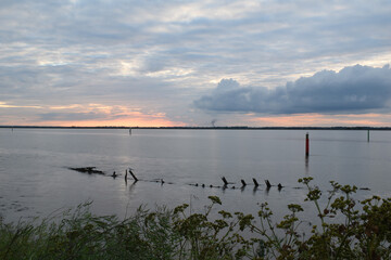 Naklejka premium Long exposure golden sunset over Breydon Water, a stretch of the River Yare at Great Yarmouth, Norfolk, UK