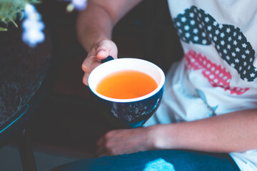 A cup of tea and a girl`s hands. For balcony concept. Fresh summer image for your design.