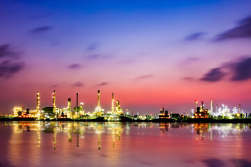 Obraz premium Bangchak Oil Refinery, a view of oil refinery along Chaopraya river at sunrise with reflection in the water, Bangkok, Thailand