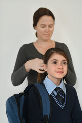 Mother preparing her  daughter to go to school