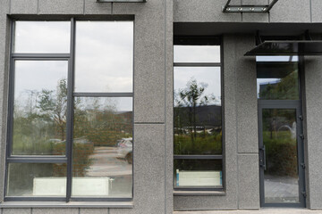 Abstract fragment of modern architecture, gray walls, glass and concrete.
