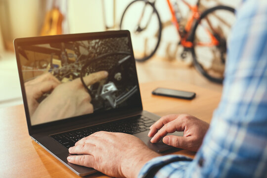 A man is studying bicycle repair using an online video tutorial.