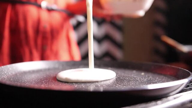 Closeup slow motion view of steaming hot 'Dosa' on a nonstick pan. Dosa is the Indian version of pancake made with rice flour dough