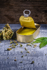 marijuana buds. medical cannabis butter in a open tin can. hemp leaves. vertical orientation. on...