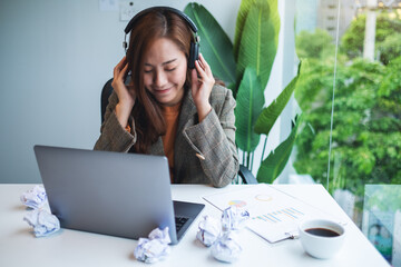 A beautiful young businesswoman enjoy listening to music to relieve stressed at work